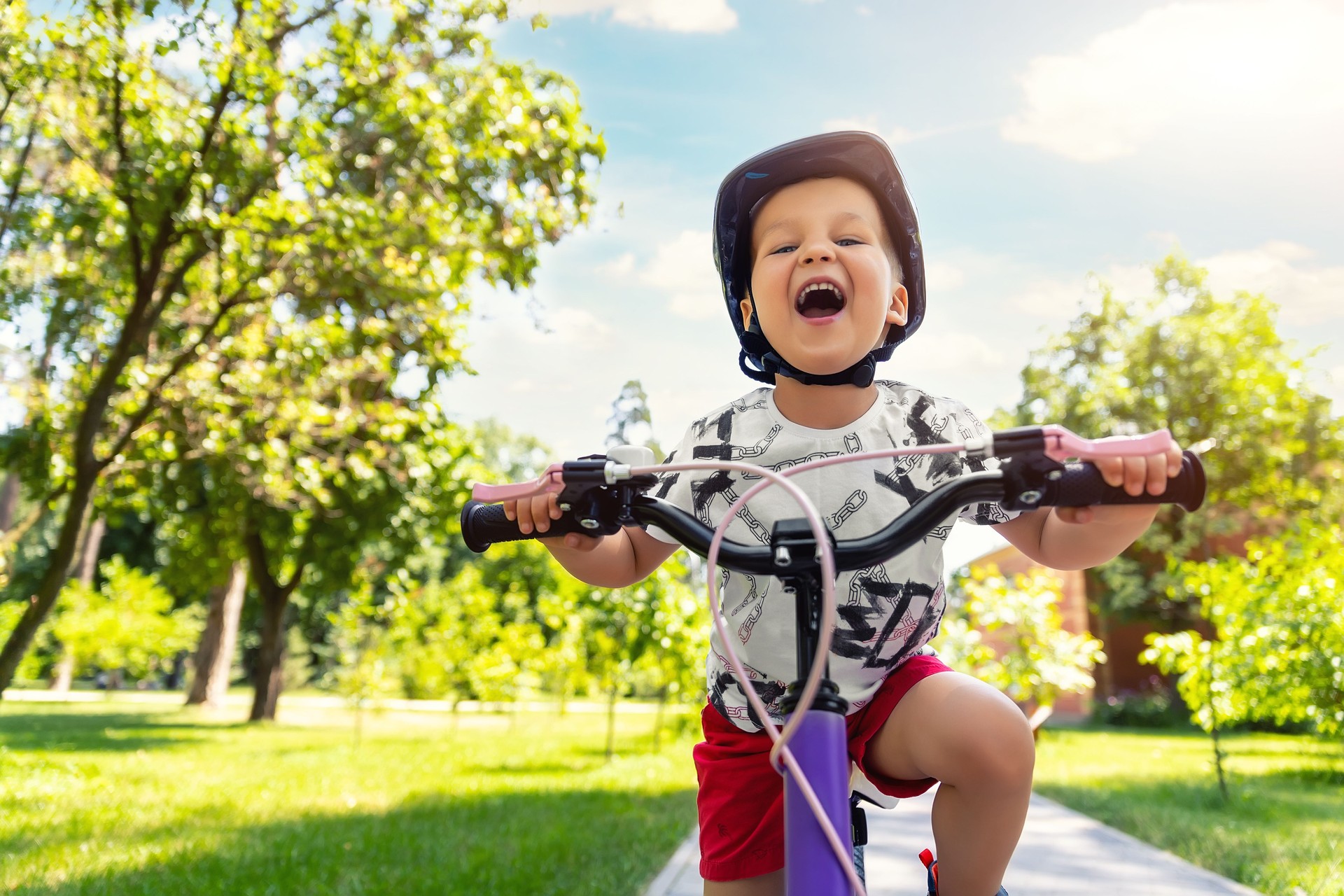 Porträt kleine süße entzückend kaukasische Kleinkind Junge in Schutzhelm genießen Spaß spaß fahrrad fahren in Stadtpark Straße Hof Garten Wald. Kind erstes Fahrrad. Kinder im Freien Sport Sommeraktivitäten