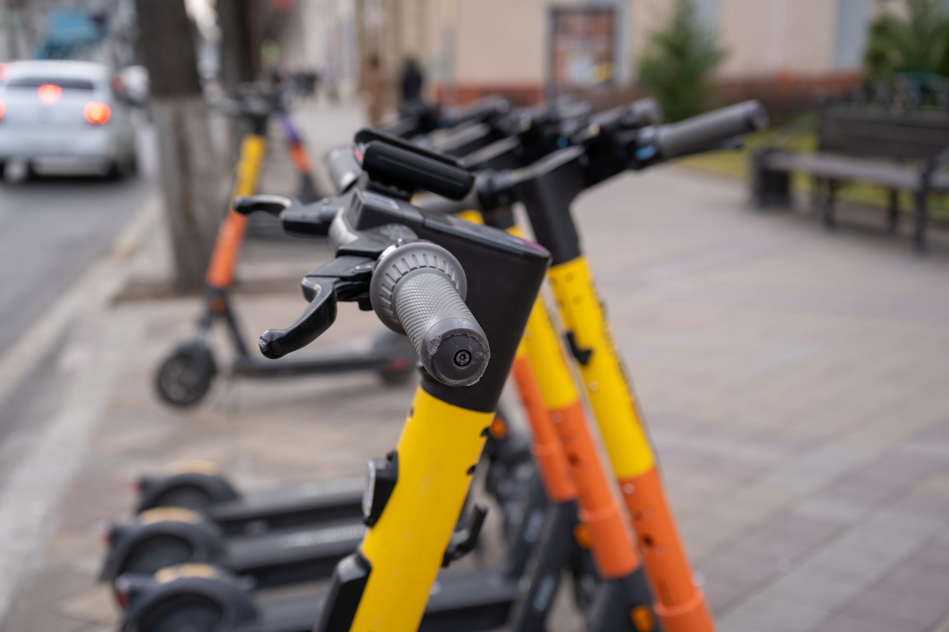 Elektrischer Stadtverkehr. Die Reihe der elektrischen Vorbereitungen, um Roller-Bikes mit Akkumulatoren im Zentrum einer Stadt auf dem Bürgersteig Stein zu fahren