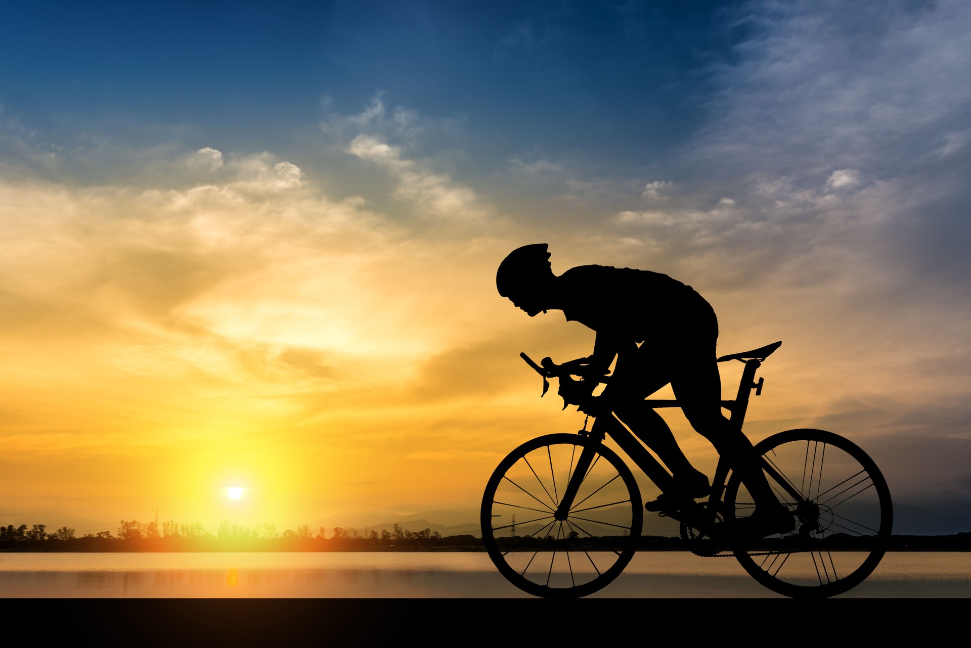 Silhouette der Radfahrer auf dem Hintergrund der schönen Sonnenuntergang